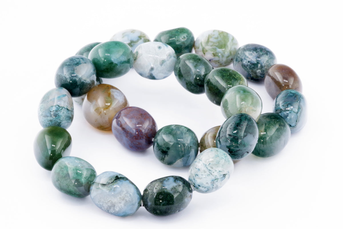 Close-up of natural polished stones in shades of green, blue, brown, and white, arranged as a Moss agate bracelet – Gem with smooth, rounded beads.