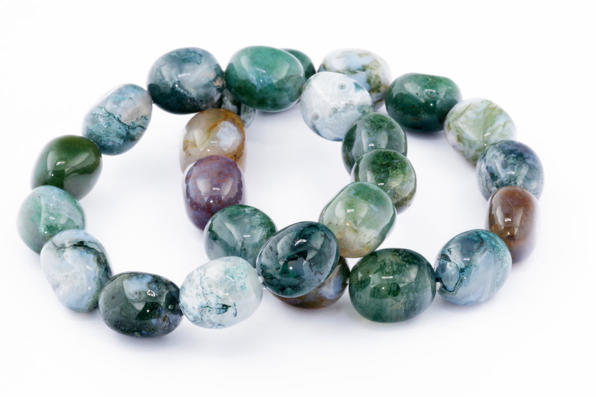 Close-up of polished natural crystals in various green, white, and brown tones, arranged as a Moss agate bracelet – Gem highlighting its smooth, glossy gemstone beads.