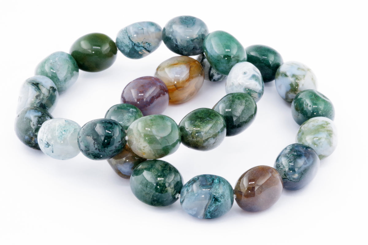 Close-up of polished natural gemstones in shades of green, white, and brown arranged as a Moss agate bracelet – Gem, showcasing unique patterns and translucent textures.