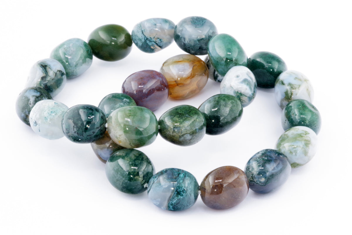 Close-up of a polished moss agate bracelet – Gem featuring smooth, multicolored natural crystal beads with green, blue, and brown tones arranged on a white background.