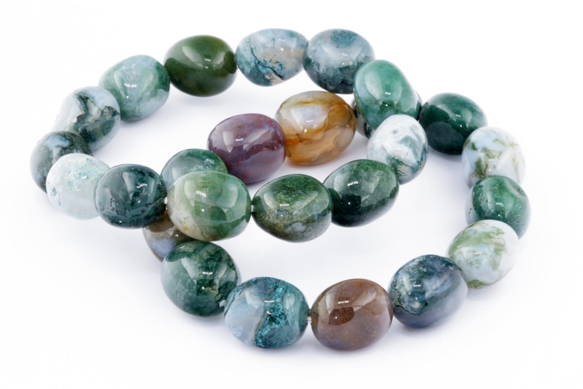 Close-up of polished multicolored natural gemstones forming a Moss agate bracelet – Gem, showcasing green, white, brown, and translucent hues on a white background.