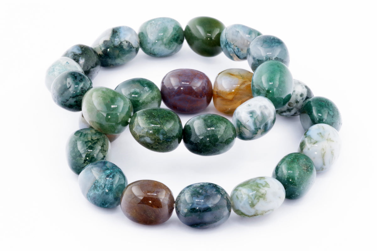 Moss agate bracelet – Gem featuring polished green, white, and brown natural crystals arranged on a white background, highlighting the unique patterns in each bead.