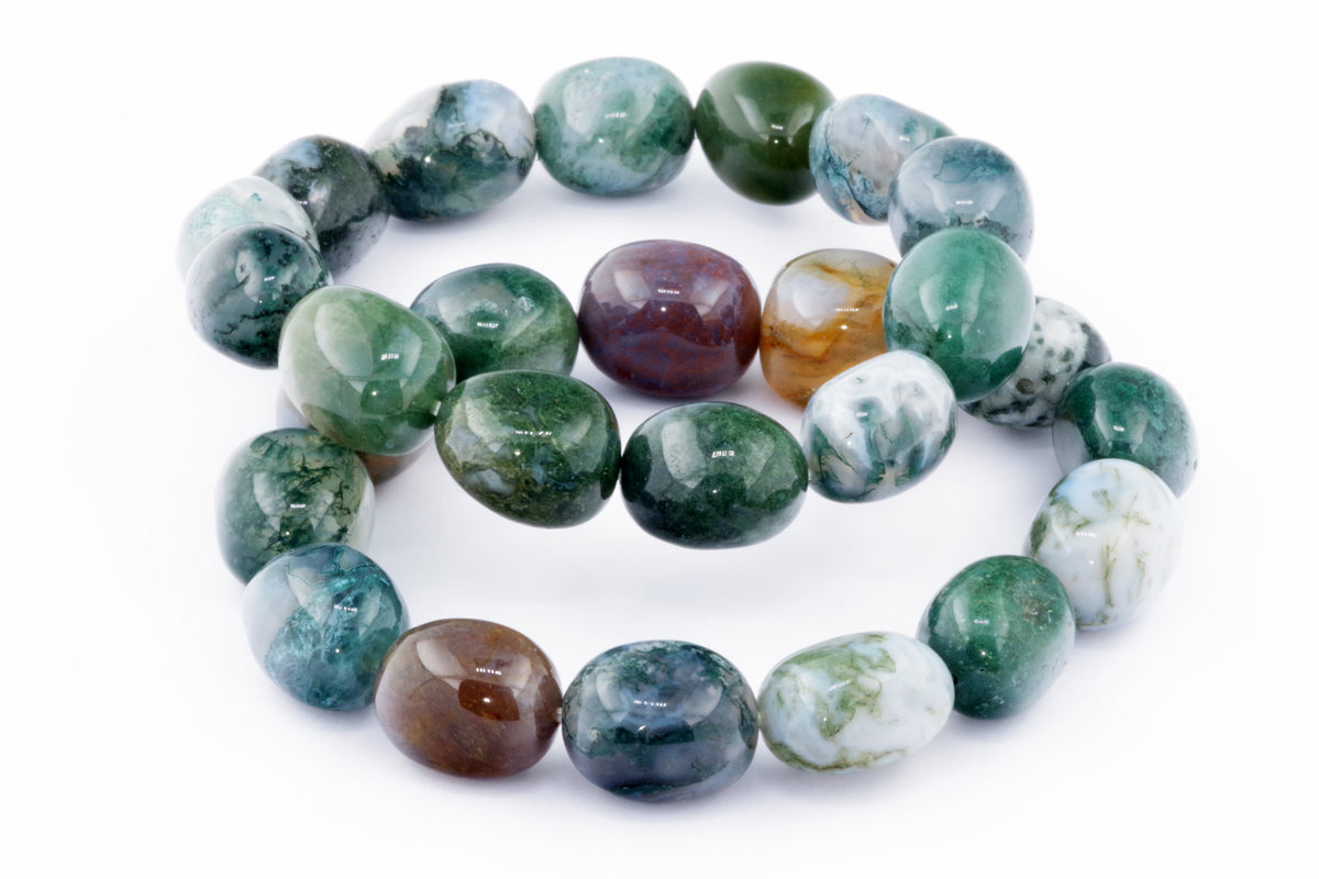 Close-up of polished natural crystal beads in shades of green, white, brown, and blue arranged as a Moss agate bracelet – Gem, highlighting unique mineral patterns and textures.