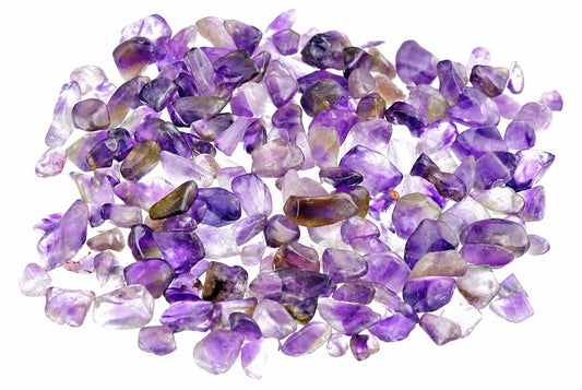 A loose pile of small amethyst pieces shows purple and pale translucent surfaces, spread across a plain white background.