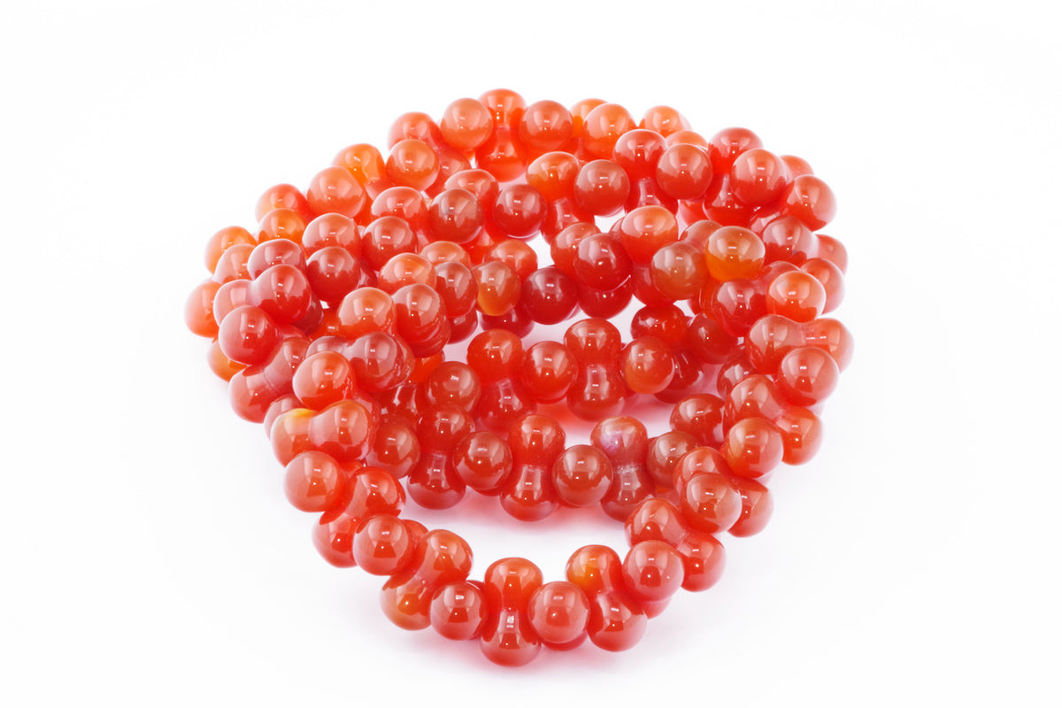 Carnelian bracelet – DNA featuring polished, vibrant orange carnelian beads arranged in a smooth, round shape, perfect for crystal jewelry and healing crystal collections.