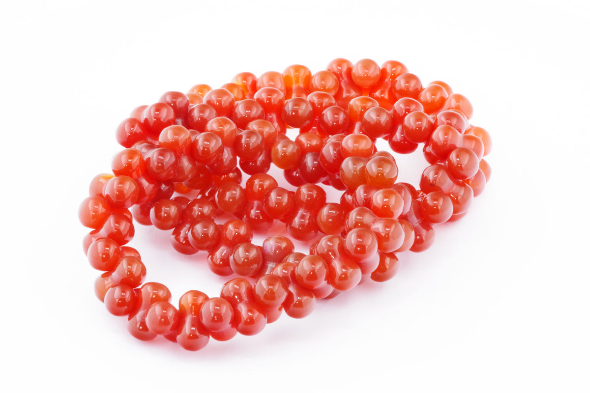 Carnelian bracelet – DNA featuring polished natural carnelian gemstones arranged in a unique spiral design, a vibrant crystal jewellery piece for energy and grounding.