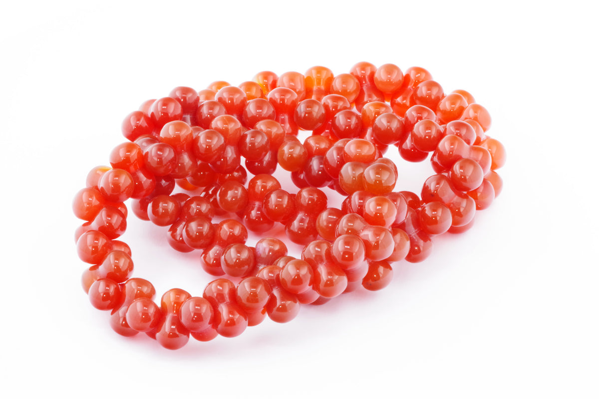 Carnelian bracelet – DNA featuring polished, vibrant orange-red natural carnelian crystal beads arranged in a continuous loop, ideal for crystal jewellery and healing practices.