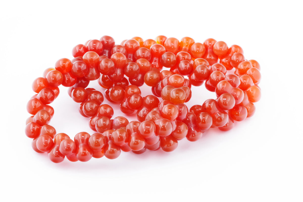 Carnelian bracelet – DNA featuring polished orange-red carnelian gemstones strung together to create a vibrant, natural crystal bracelet ideal for energy and grounding.