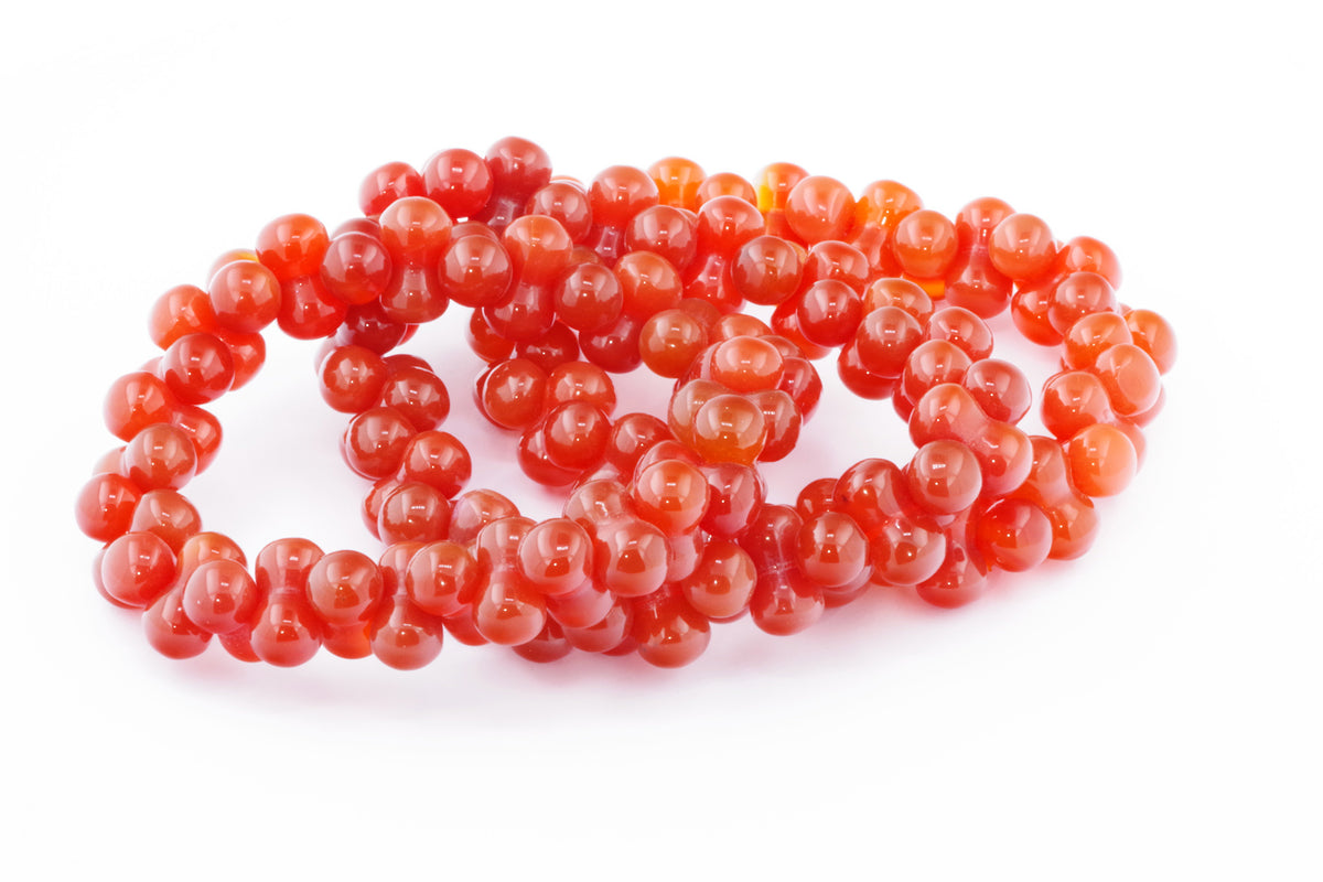 Carnelian bracelet – DNA featuring polished round carnelian gemstone beads in vibrant shades of orange and red, ideal for crystal jewellery and healing crystal collections.