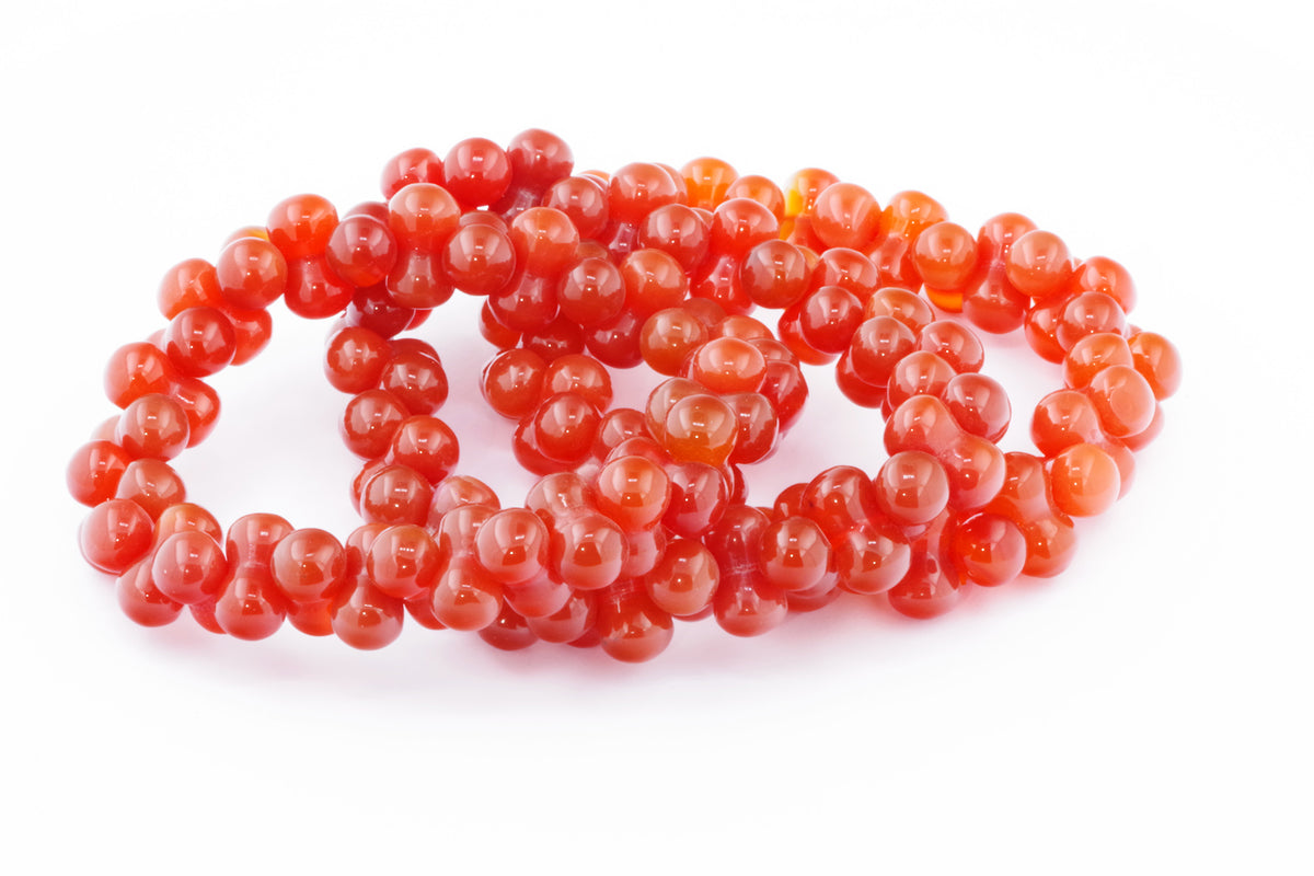 Three polished Carnelian bracelet – DNA strands made of vibrant orange natural crystal beads arranged on a white background, highlighting their rich color and smooth texture.