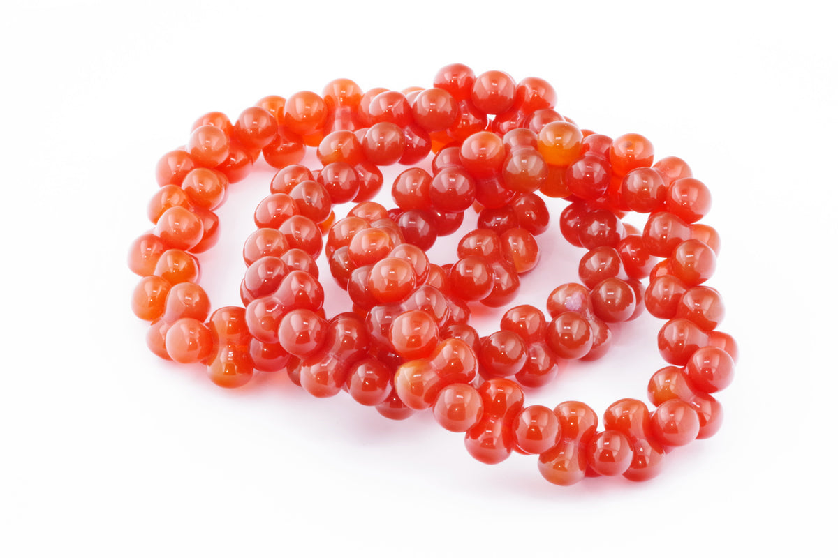 Carnelian bracelet – DNA made of polished natural carnelian beads in vibrant orange and red tones, forming a smooth, round crystal bracelet for energy and grounding.