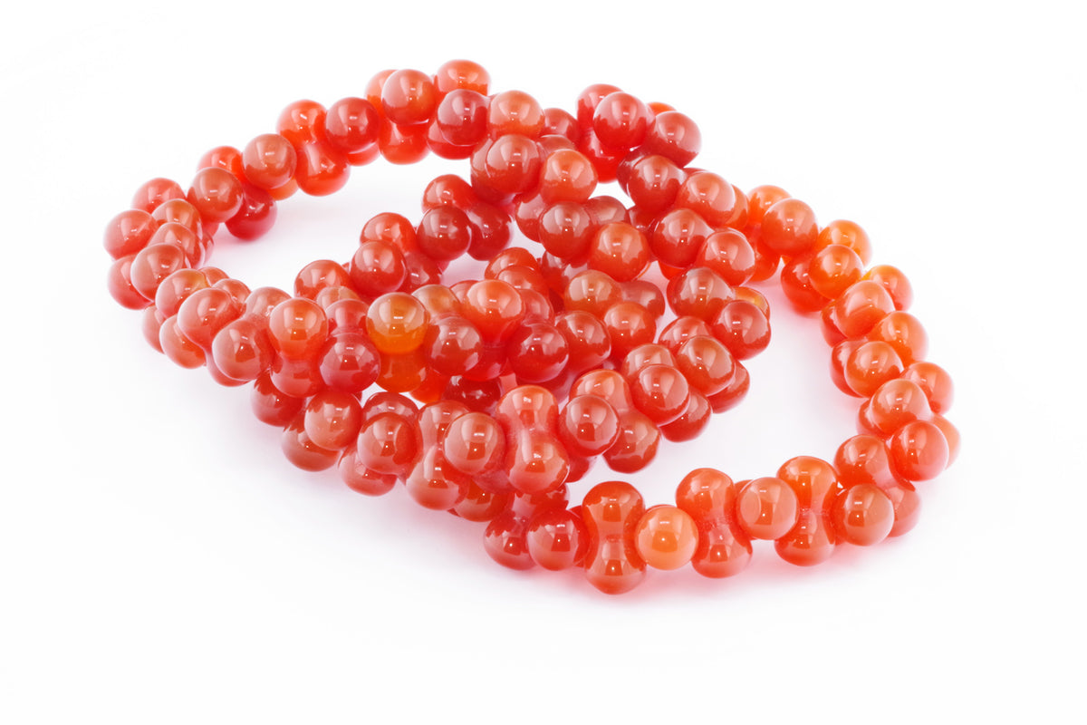 Carnelian bracelet – DNA with polished bright orange-red carnelian beads arranged in an intricate loop design, showcasing natural crystal gemstone jewelry.