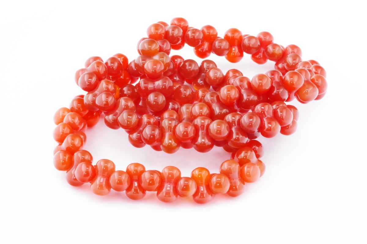 Carnelian bracelet – DNA featuring polished vibrant orange carnelian crystal beads arranged in a flexible strand, ideal as a natural crystal jewellery piece.