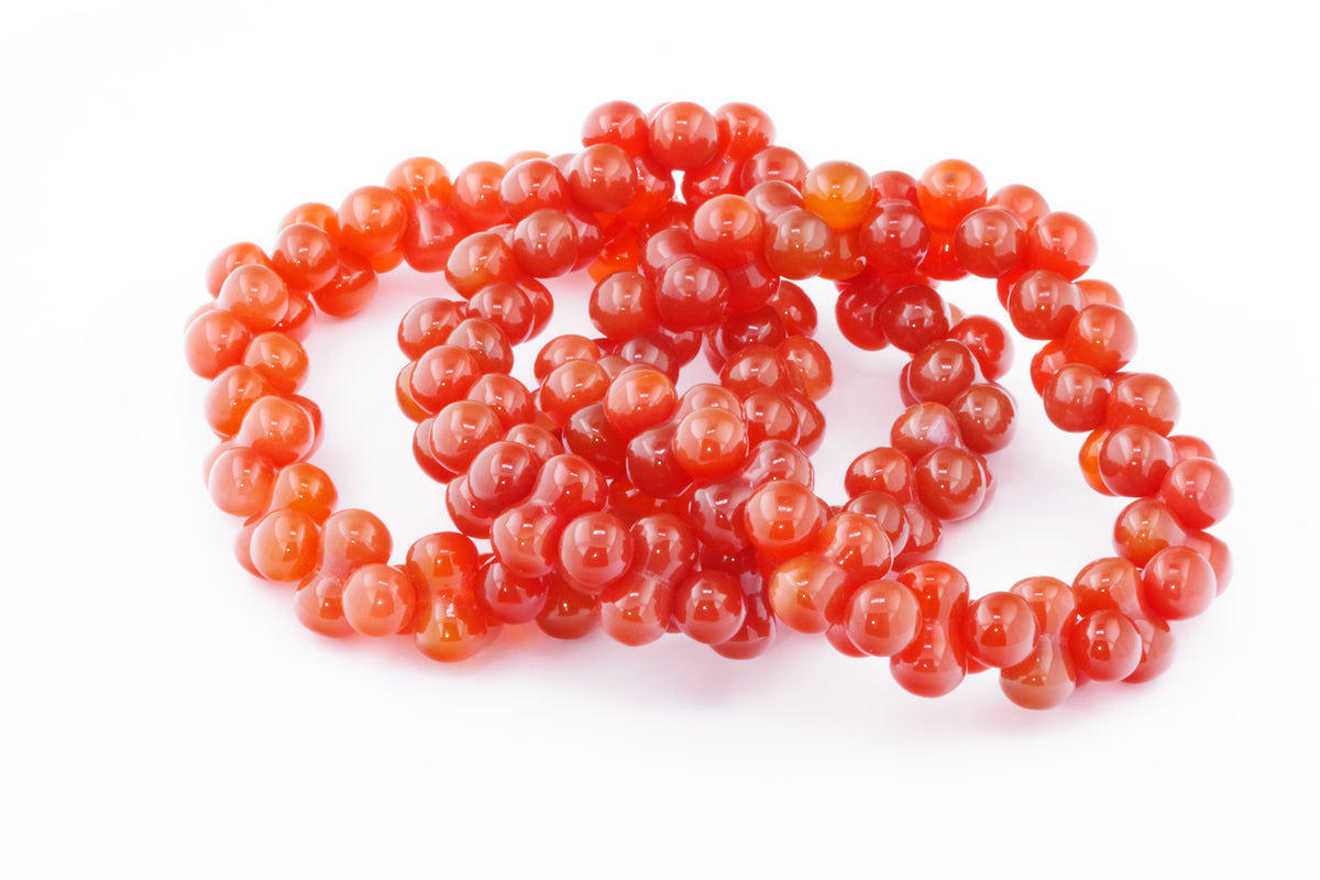 Carnelian bracelet – DNA featuring polished round carnelian beads in warm orange and red hues, arranged in a stylish crystal bracelet ideal for healing and energy.