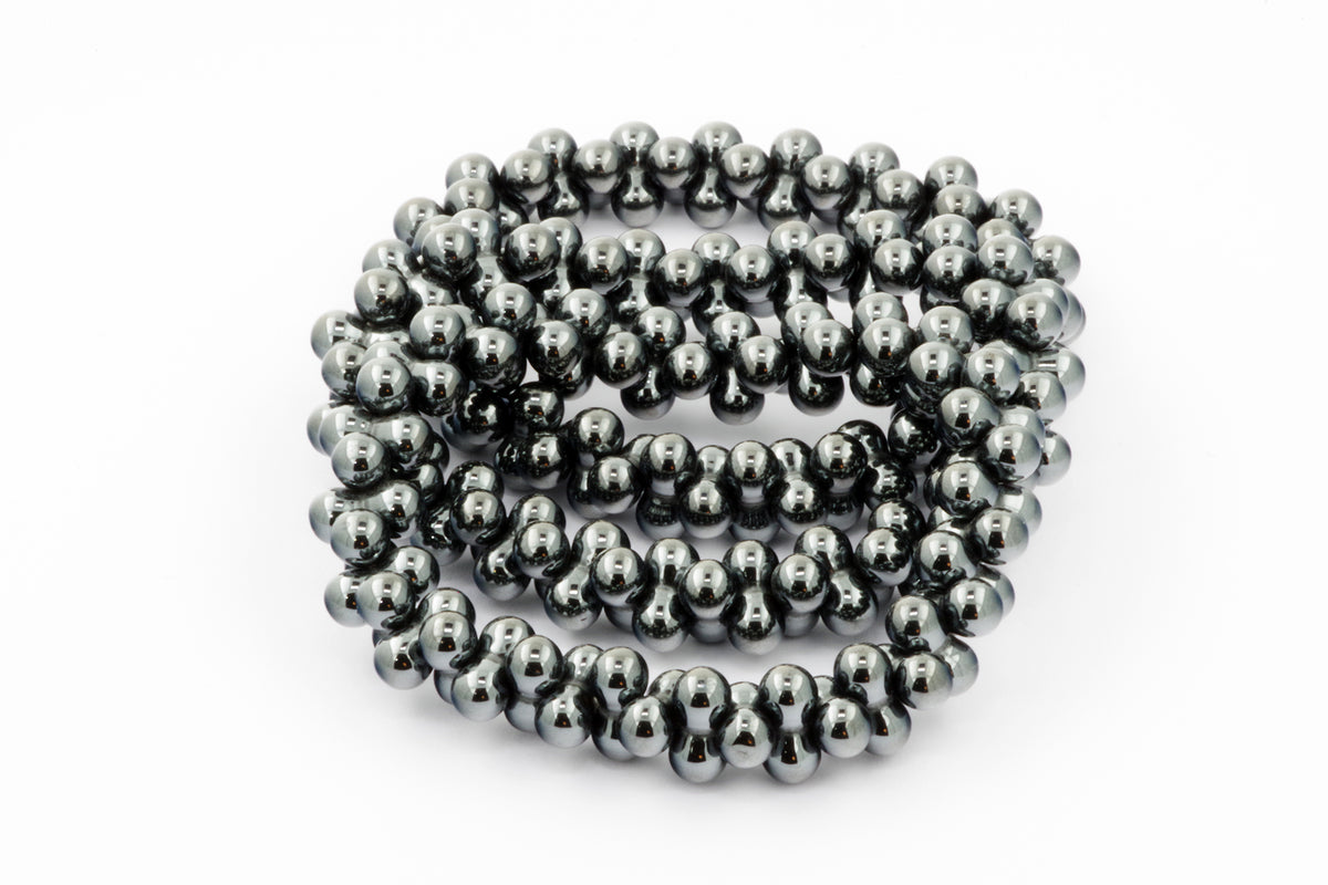 Close-up of a polished Hematite bracelet – DNA featuring smooth, reflective dark metallic beads arranged in a continuous strand, highlighting its natural crystal and mineral qualities.