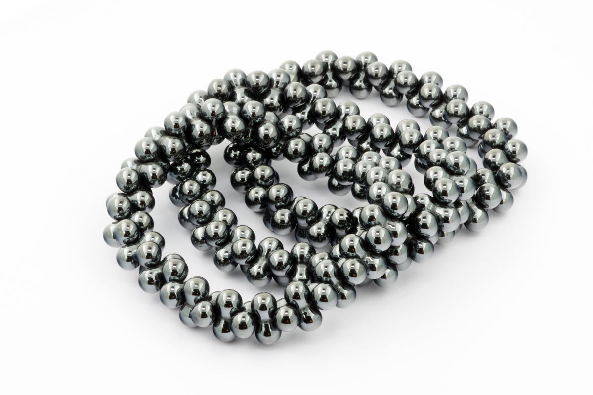 Hematite bracelet – DNA featuring polished dark metallic beads arranged in a coiled, flexible design, showcasing natural crystal elegance and grounding energy.