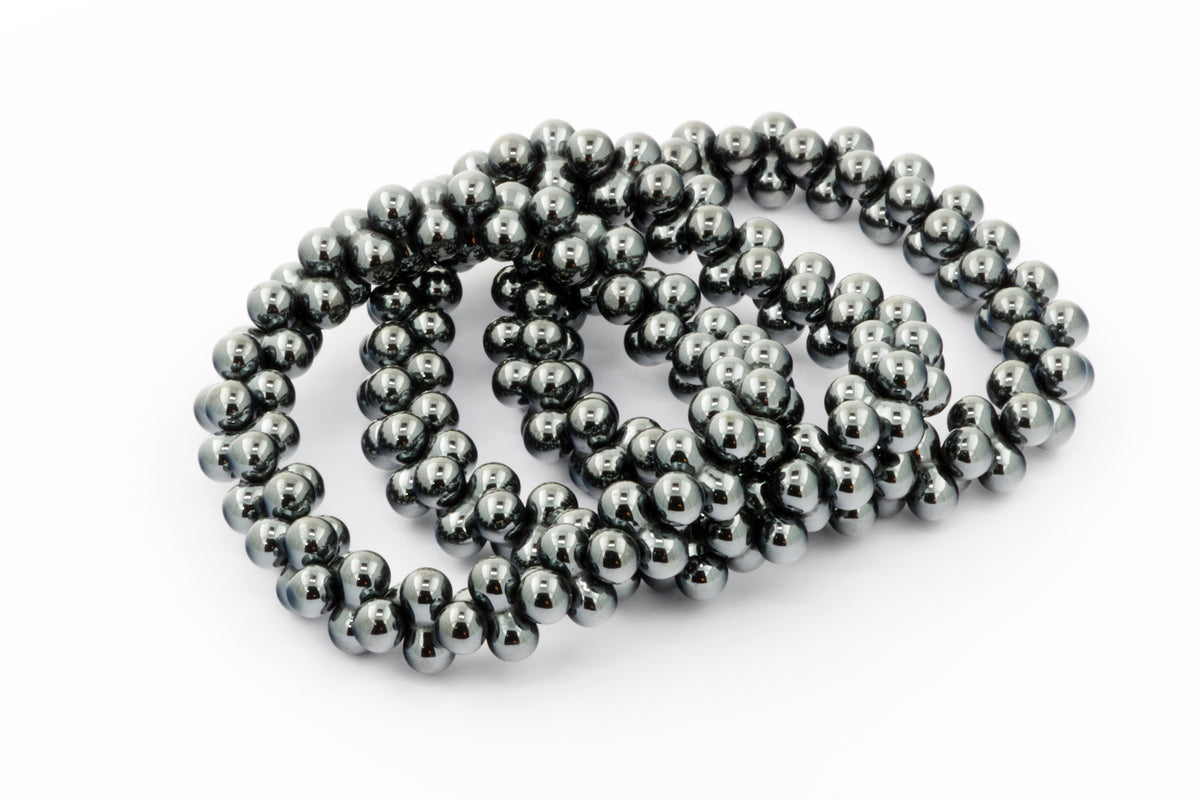 Close-up of polished hematite beads forming a reflective and smooth Hematite bracelet – DNA, showcasing its natural crystal quality and metallic shine for crystal jewellery lovers.