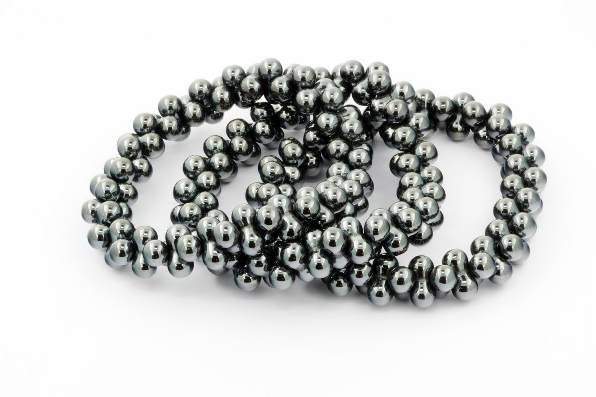 Three polished dark metallic hematite bead bracelets arranged together on a white background, showcasing the sleek and smooth finish of the Hematite bracelet – DNA.