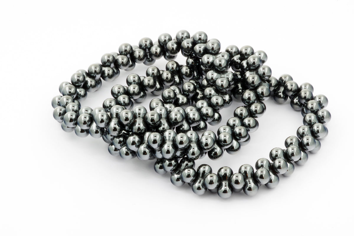 Hematite bracelet – DNA featuring polished, dark metallic beads shaped like linked double helix strands, highlighting the natural mineral's smooth texture and reflective surface.