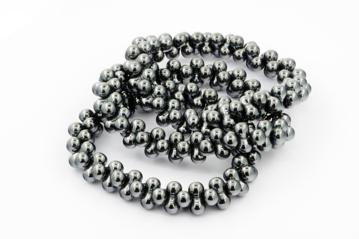 A polished Hematite bracelet – DNA featuring smooth, reflective dark metallic beads arranged in a continuous loop, highlighting natural crystal energy and grounding properties.