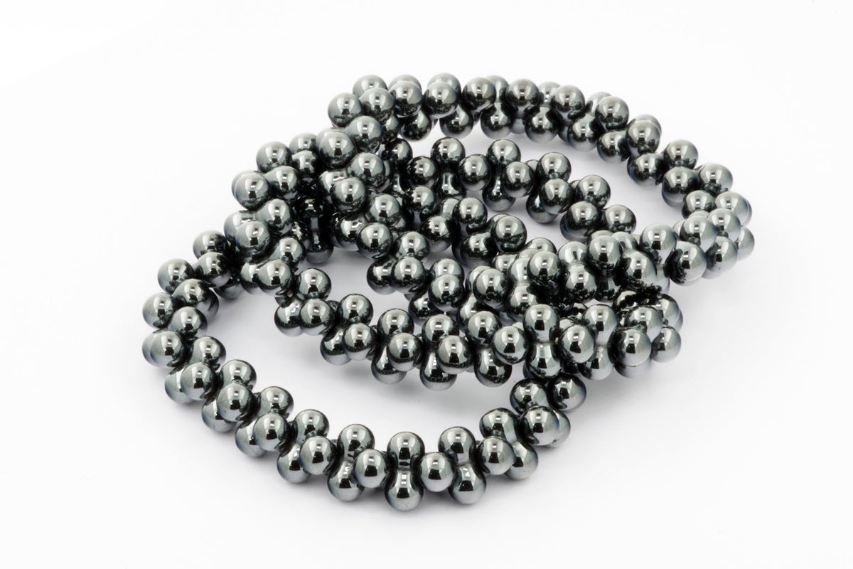 Close-up of a shiny Hematite bracelet – DNA strand made of polished dark gray hematite beads, highlighting its smooth texture and reflective surface.