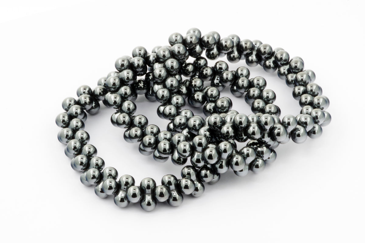 Close-up of polished hematite beads strung together in a stylish Hematite bracelet – DNA, showcasing the shiny, metallic gray natural crystal qualities ideal for crystal jewellery and grounding energy.