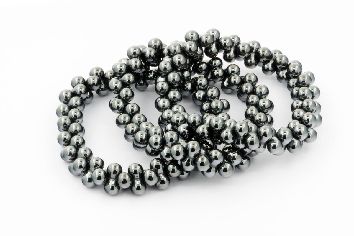 Three polished Hematite bracelet – DNA strands made of shiny dark gray natural crystal beads arranged on a white background.