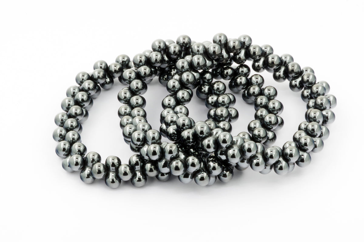 Three polished black hematite bead bracelets arranged in overlapping circles on a white background, showcasing the Hematite bracelet – DNA design.