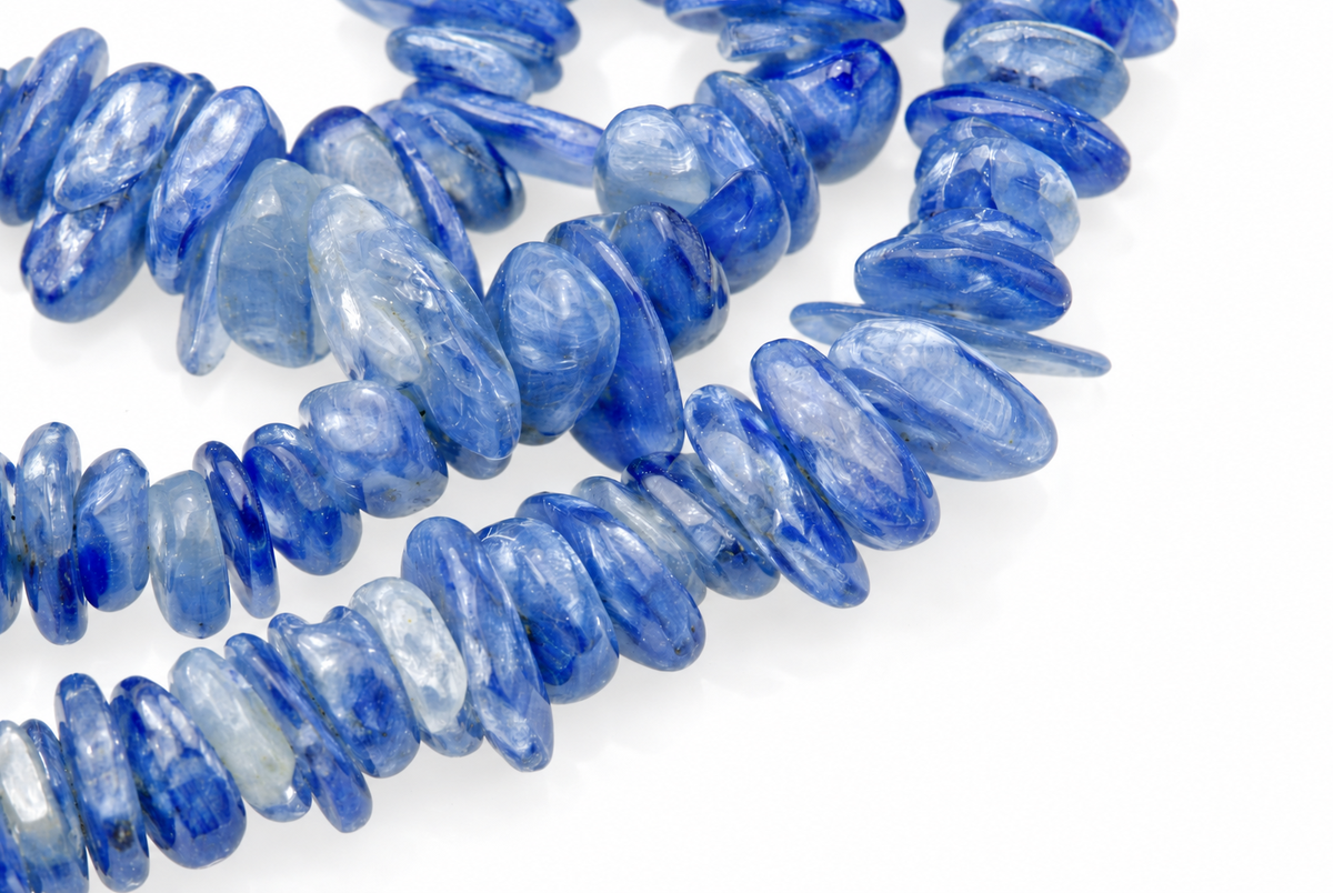 Blue kyanite chip beads arranged on a white surface.