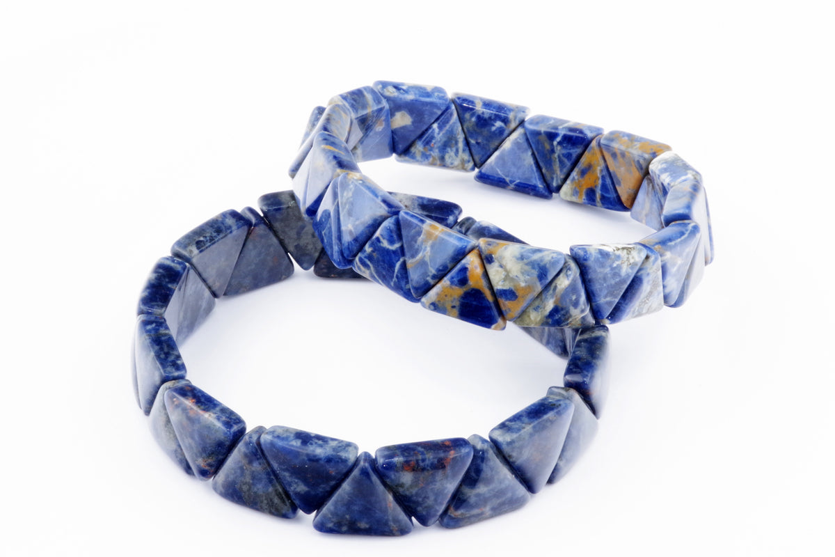 Two crystal bracelets made of polished sodalite gemstones shaped into triangles, showcasing natural blue and white mineral patterns, named Sodalite bracelet – Triangle.