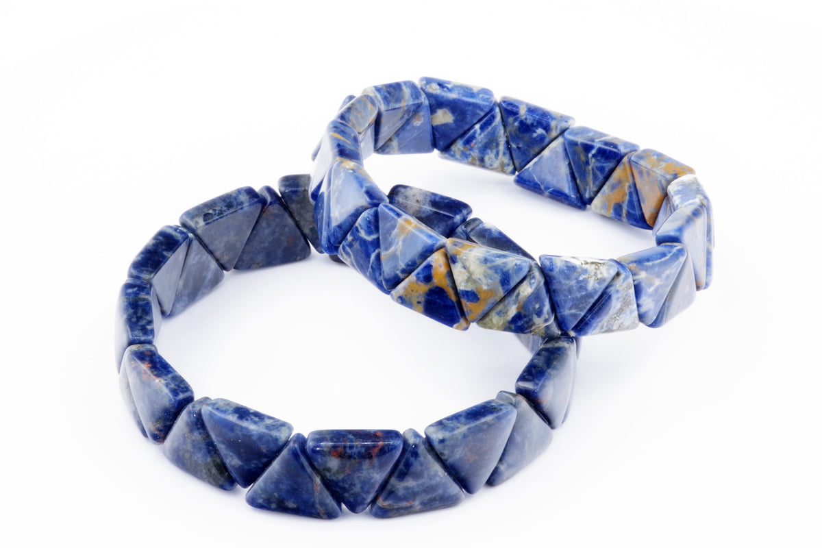 Two Sodalite bracelet – Triangle with polished blue and white crystal gemstone beads arranged on a white background as elegant crystal jewellery pieces.