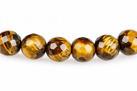 Six faceted round beads with golden brown and black stripes arranged in a row on a white surface.