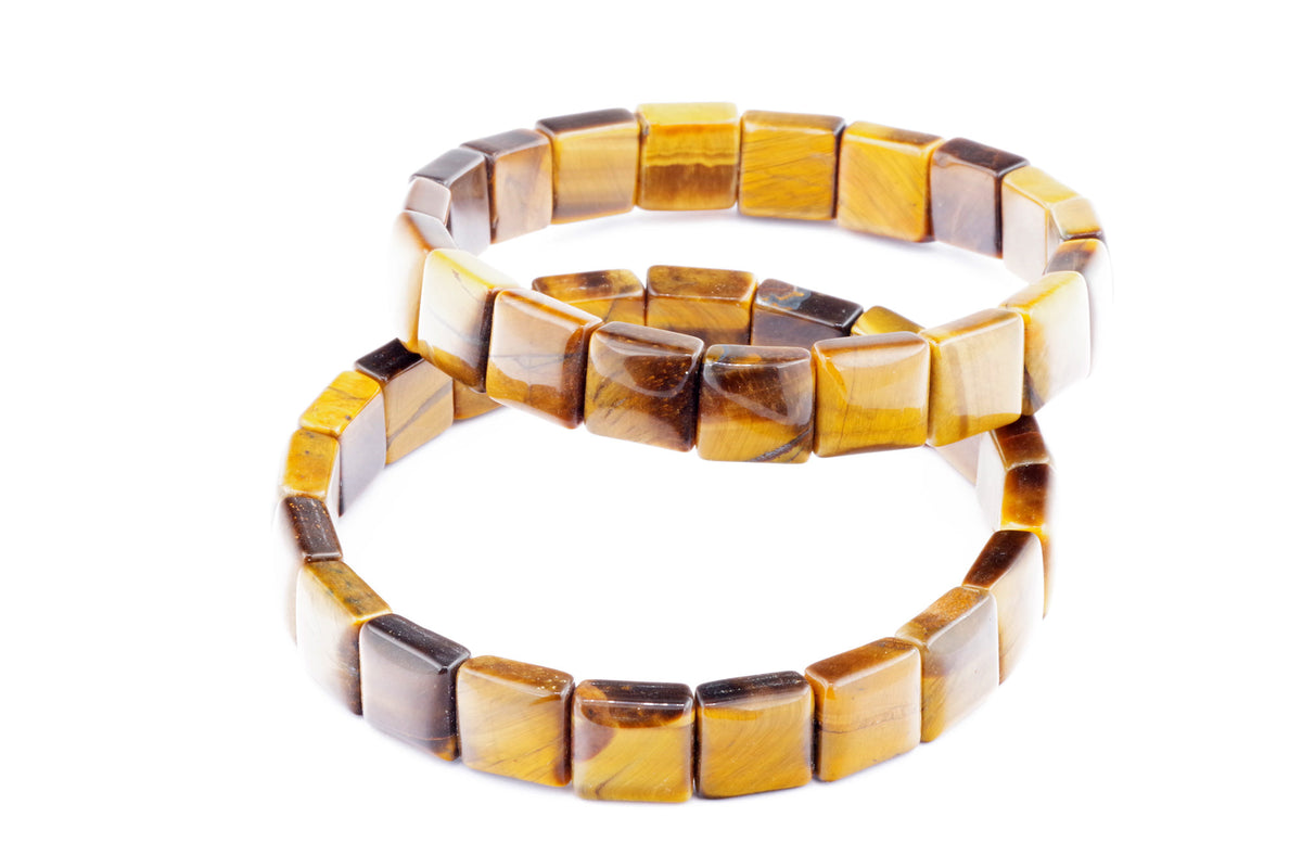 Two polished tiger's eye bracelets made of square beads showcasing natural golden brown and yellow hues in a simple elegant design for crystal jewellery lovers, named Tiger eye bracelet – Square.