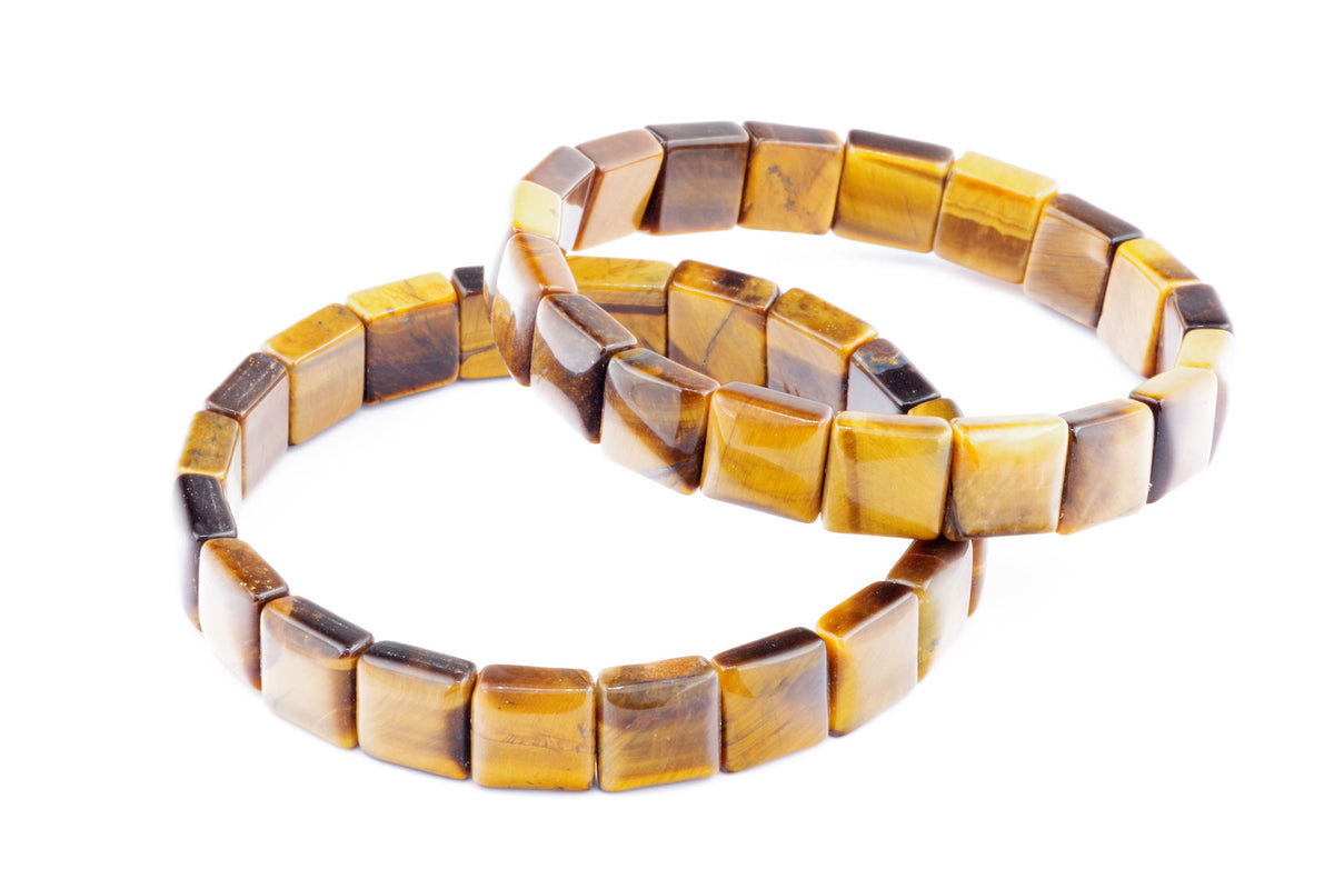 Two polished Tiger eye bracelet – Square pieces with rich golden brown and honey tones arranged on a white background, highlighting the natural crystal gemstones.