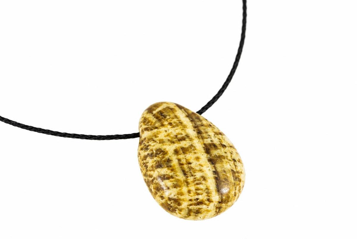Aragonite pendant with a smooth, oval shape featuring yellow and brown patterns on a black cord against a white background.