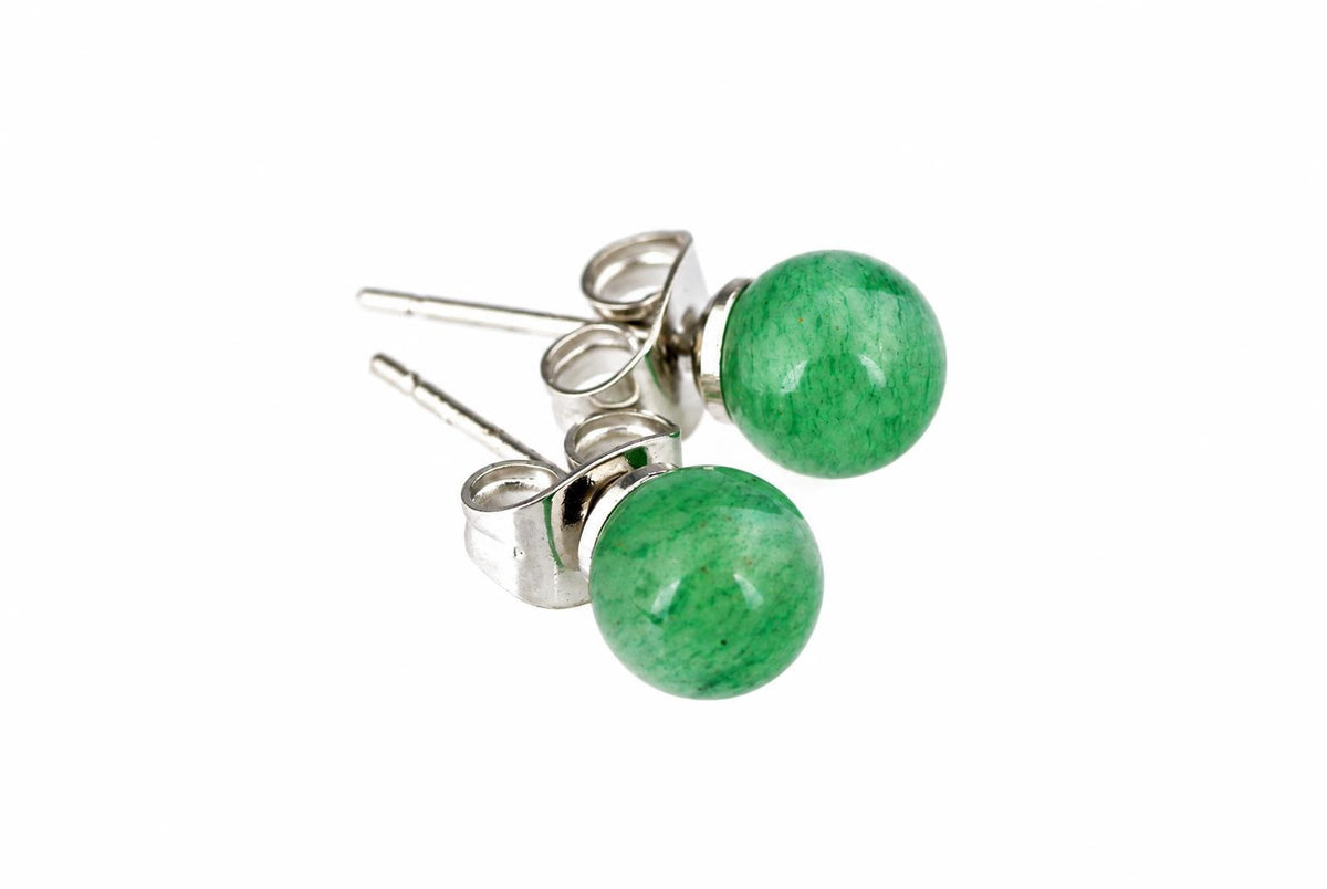 A pair of silver-toned stud earrings with round green aventurine beads on a white surface.
