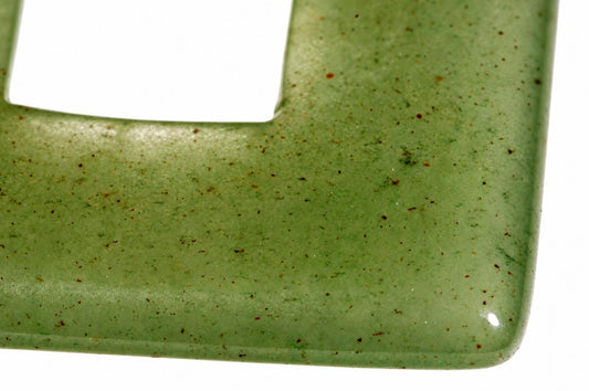 A close-up of a green aventurine pendant with brown speckles, showing a smooth surface and rounded corner against a white background.