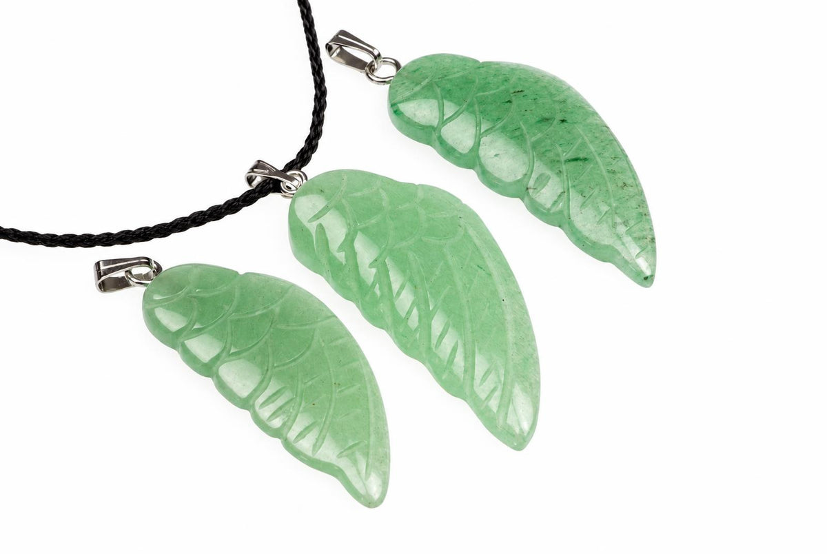 Three green aventurine pendants shaped like wings, each with carved vein details and a silver-toned bail on a black cord against a white background.