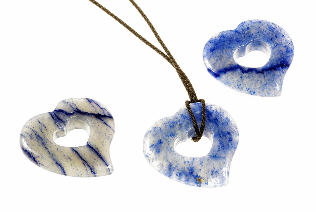Three heart-shaped pendants with blue and white patterns, one on a brown cord against a white background.