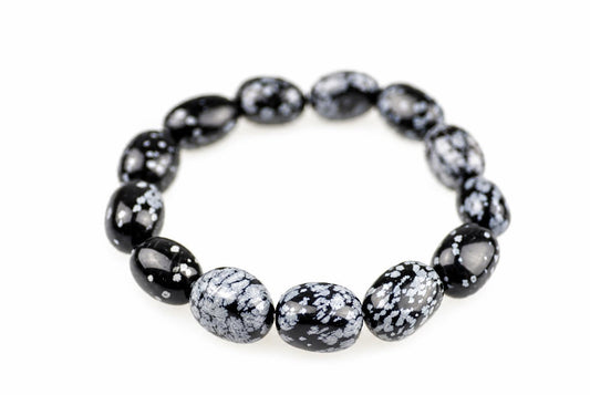 Bracelet of glossy oval black beads with pale grey snowflake-like markings, arranged in a loop on a white background, with the front beads in focus.