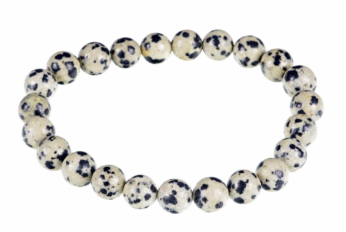 A bracelet made of round beads with a cream background and dark spots, arranged in a circle on a white surface.