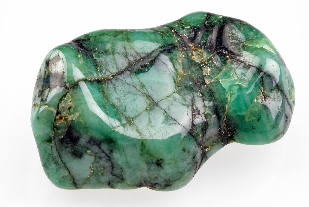 A polished, irregularly shaped stone with green, white and dark veins, resting on a pale surface.