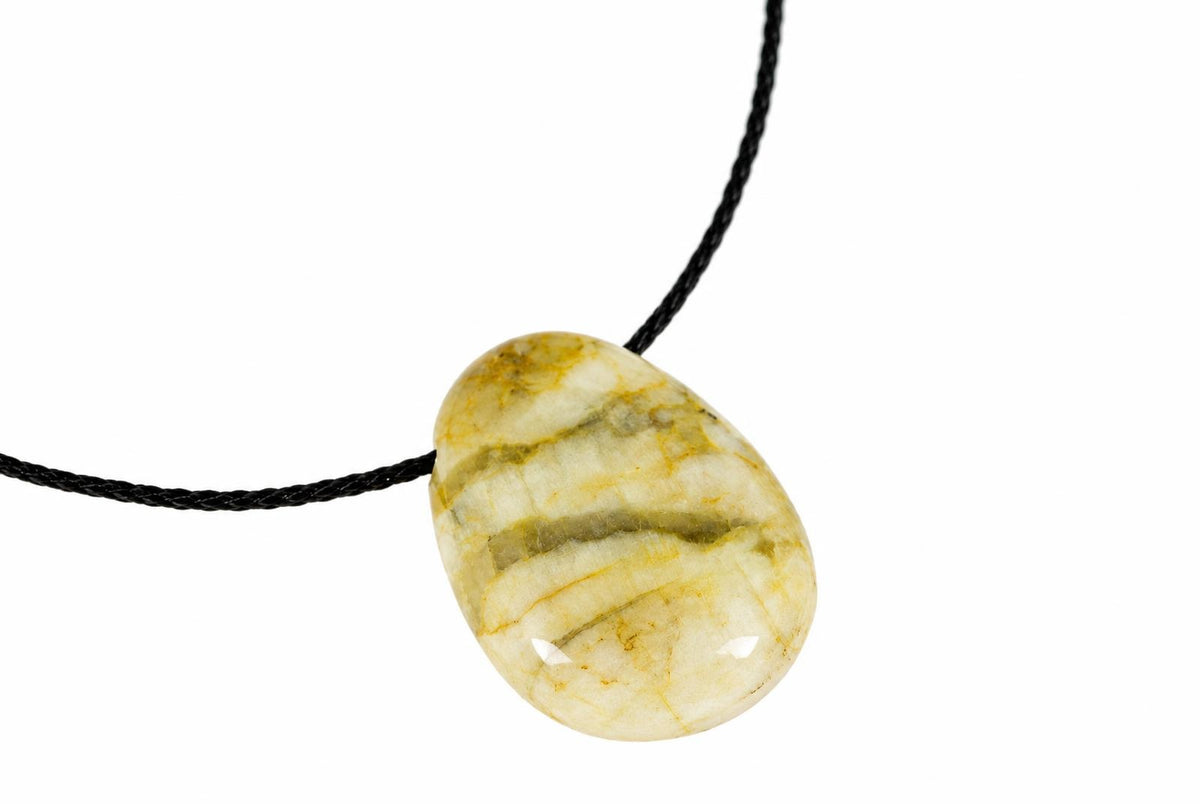 A polished, oval-shaped pendant with cream and yellow-brown stripes hangs from a black cord against a white background.