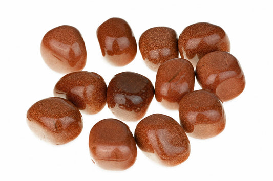 Twelve polished, brownish-red stones with a speckled texture are arranged on a white surface.