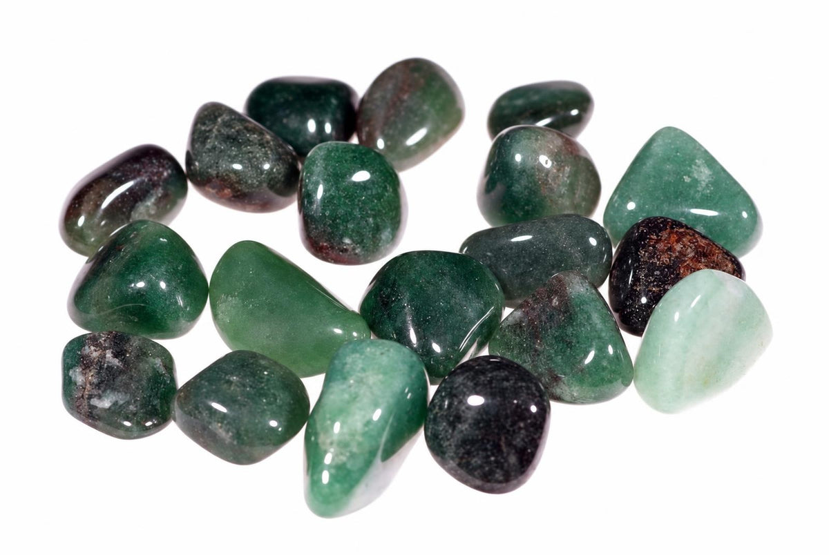 A collection of polished green aventurine stones in various shades, including dark green, black, and pale green, arranged on a white surface.