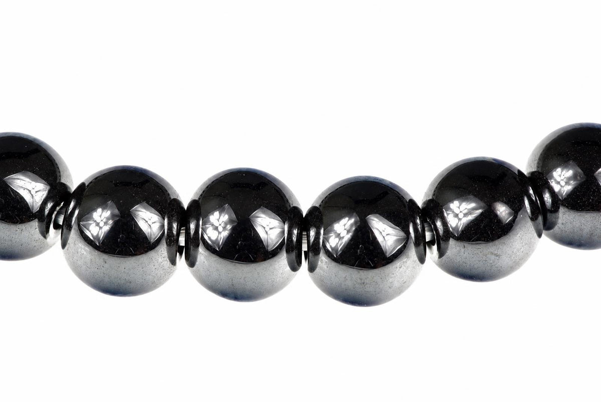 A row of round, dark beads with silver-toned floral inlays on a white background.
