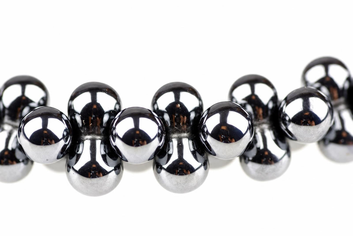 A bracelet with shiny, dark silver-toned spherical beads arranged in a row on a white background.