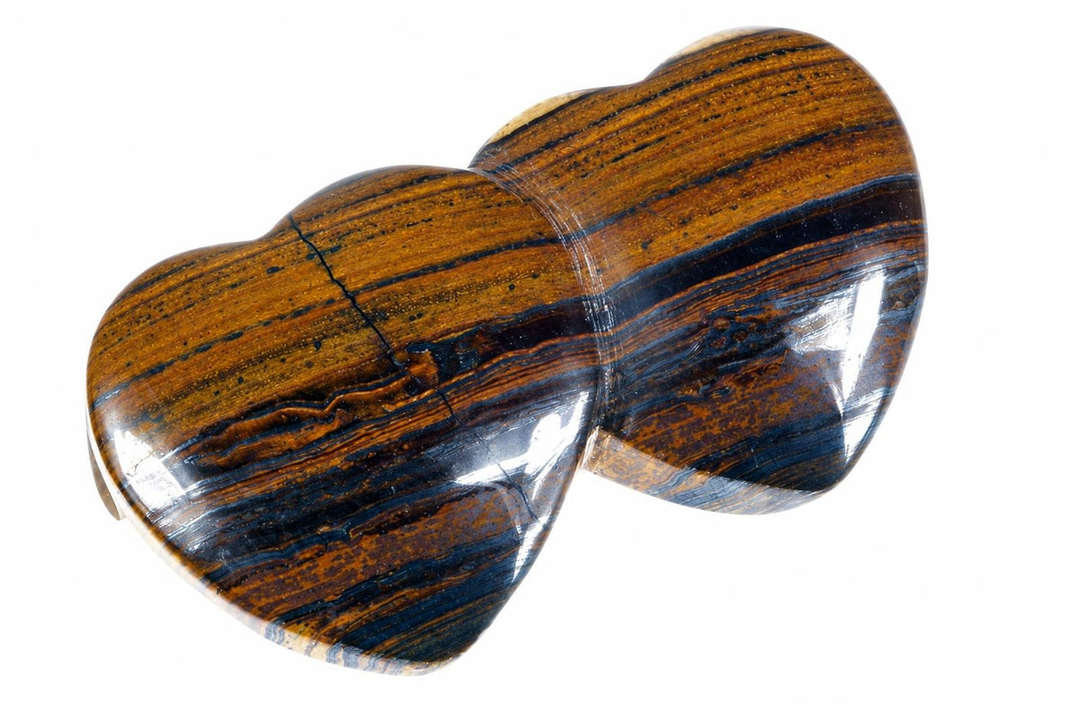 A polished, heart-shaped pendant with dark brown and black striped tiger eye stone on a white background.