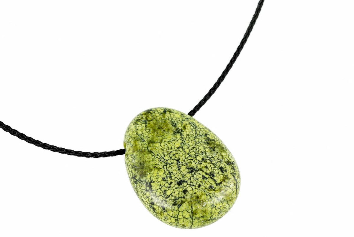 A green and black patterned oval pendant on a dark cord against a white background.