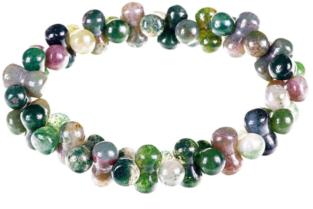 A bracelet of round, polished beads in green, white, pink and dark blue with speckled patterns on a pale surface.